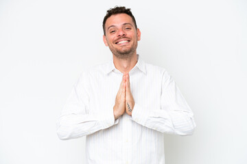 Young caucasian handsome man isolated on white background keeps palm together. Person asks for...
