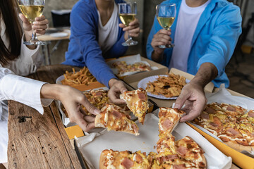 Group of male and female colleagues having pizza lunch together at the office after work celebration concept