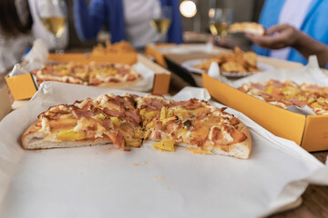 Group of male and female colleagues having pizza lunch together at the office after work celebration concept
