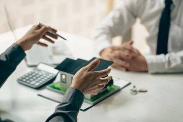 Home agents talk to new home buyers and offer good interest rates and calculate clients on mortgage financing to help make real estate concept decisions.