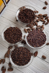 Cacao nibs with cacao beans on old wooden background