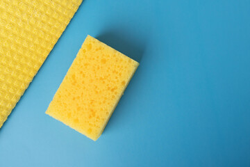 cleaning service, disinfection,yellow sponge and rag on blue background