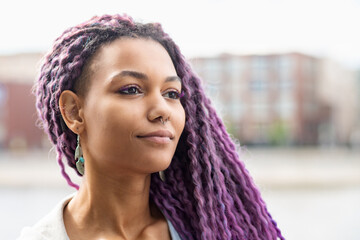 young african woman with purple curls and nose piercing close-up