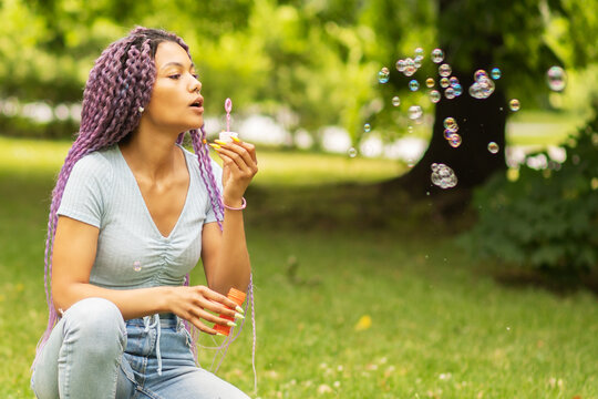 modern happy young african woman blowing bubbles