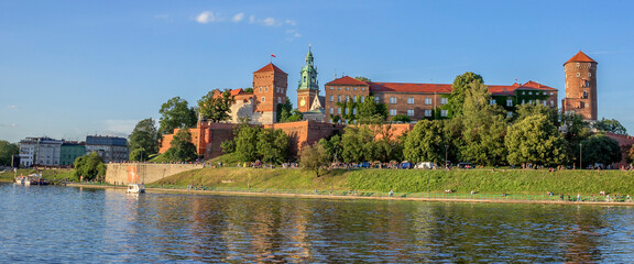 Widok na Zamek królewski Wawel w Krakowie z brzegu rzeki Wisła. Piękna letnia pogoda w Polsce.