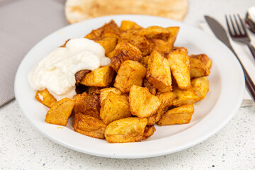 Baked potato wedges on white table background