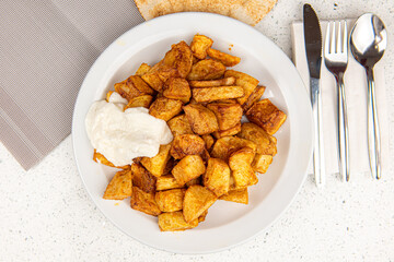 Baked potato wedges on white table background
