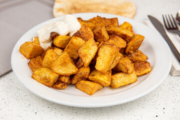 Baked potato wedges on white table background