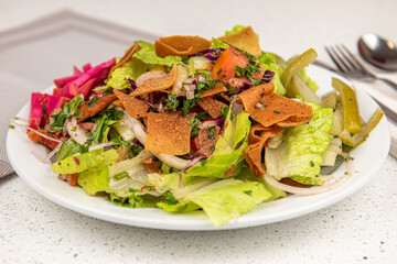 Healthy fattoush salad closeup. The key ingredient in this middle eastern dish is the toasted pita bread which is mixed with healthy vegetables, herbs and a dressing made with lemon and sumac.