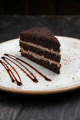 chocolate cake with cream on a wooden background