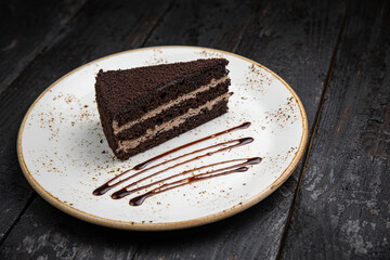 chocolate cake with cream on a wooden background