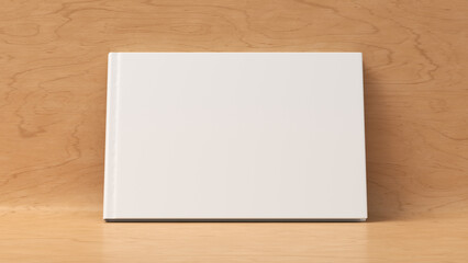 Blank horizontal hardcover book cover mockup standing on wooden background