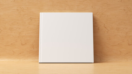 Blank square hardcover book cover mockup standing on wooden background