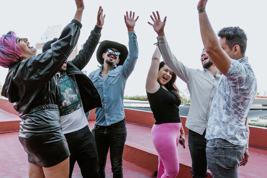 Group Of Lgbt Latin Friends Women And Men Greeting With High Five Hand Gesture In A Rooftop In Mexico