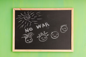 children's drawing with chalk on a black board, faces and the sun
