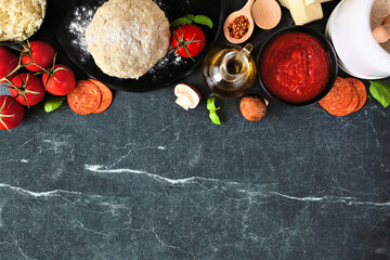 Pizza making ingredients including cheese, pepperoni, tomatoes and basil. Above view top border...