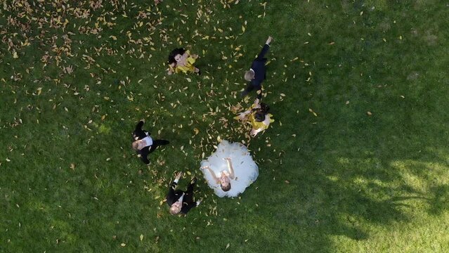 Aerial view happy wedding couple throws leaves up in a beautiful autumn Park.