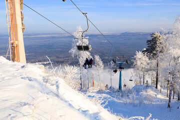 lift with benches on the cable car, the trees are covered with frost against the background of a winter landscape