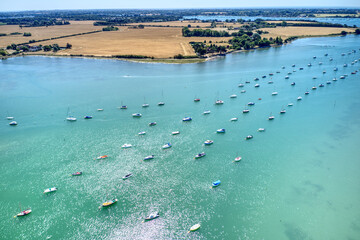 Bosham estuary full of boats with Motorboats and Sailing boats navigating between them while the...