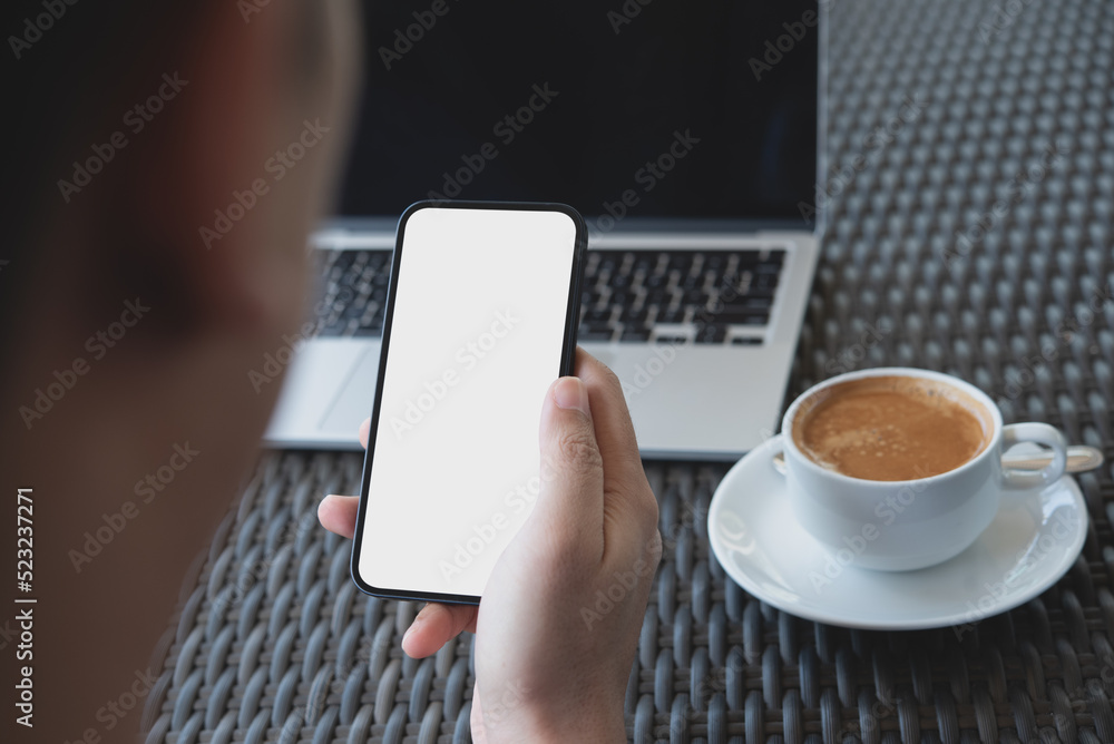 Wall mural Cell phone blank white screen mockup. Man hands holding, using mobile phone at office background, template for advertisement