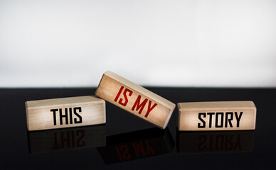 The symbol of my history. Words This is my story written on wooden blocks and white and black background with reflection. Business and my story concept.