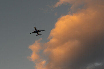 Silhouette of an airplane on sunset background.