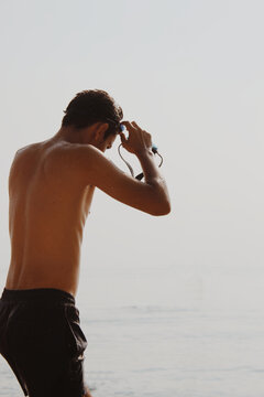 young man watching the autumn sea with googles
