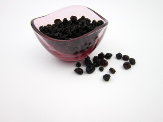 Fototapeta na wymiar Black currants on a plate and on a white surface background, black currants on a plate, 