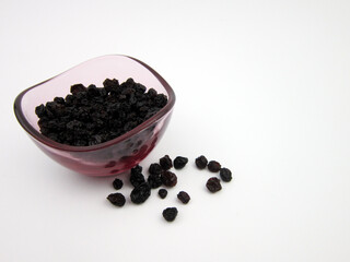  Black currants on a plate and on a white surface background, black currants on a plate,           