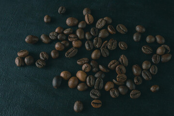 Roasted coffee beans on a dark background. Coffee beans. Cup of coffee. Coffee theme. Type of drink. Coffee house. 