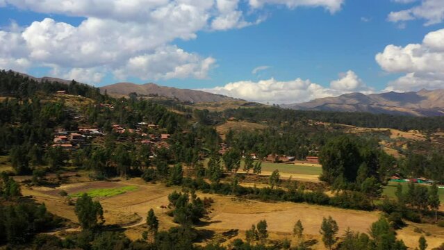 Aerial Panning Beautiful Shot Of Town On Landscape By Mountains, Drone Flying During Sunny Day - Cusco, Peru