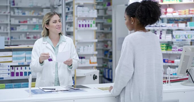 Professional female healthcare pharmacist helping customer buy medicine at the counter in a pharmacy. Woman health consultant or doctor getting medication for patient in a medical clinic store.