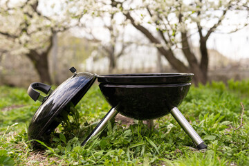An empty barbecue grill stands in the yard