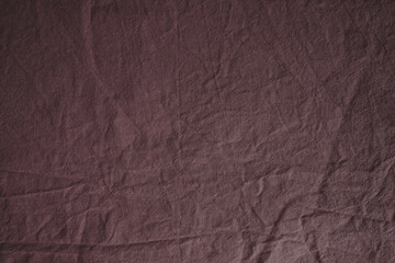Fototapeta premium Textured fabric in the color of a dusty rose. Fabric background. Crumpled bed. Cotton texture. Calico bed sheet. Pink material. Home comfort. Textile industry.