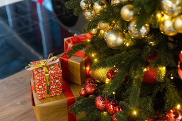 Beautiful Christmas gift boxes on floor near fir tree in room