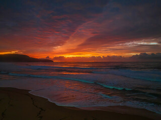 Fototapeta na wymiar Cloud covered sunrise at the seaside in pink and blue