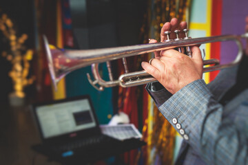 Concert view of a male trumpeter, professional trumpet player with vocalist and musical during jazz...