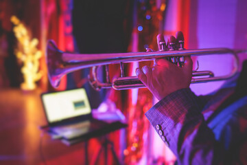 Concert view of a male trumpeter, professional trumpet player with vocalist and musical during jazz band performing in the background - obrazy, fototapety, plakaty