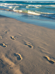 Footprints in the sand. walking by the sea. Footprints on the light sand near the surf line