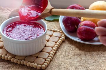Homemade plum jam preparation. Boiling , crimson, transparent jam. Selective focus