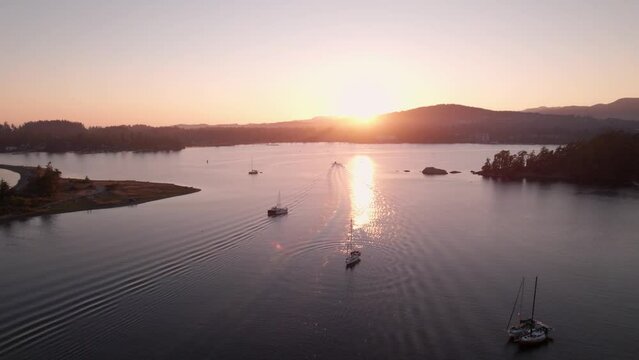 Aerial drone footage boats in harbour at sunset, Sooke BC, sail boats, marina, sunset sky. 5.4K TO 4K 24FPS.