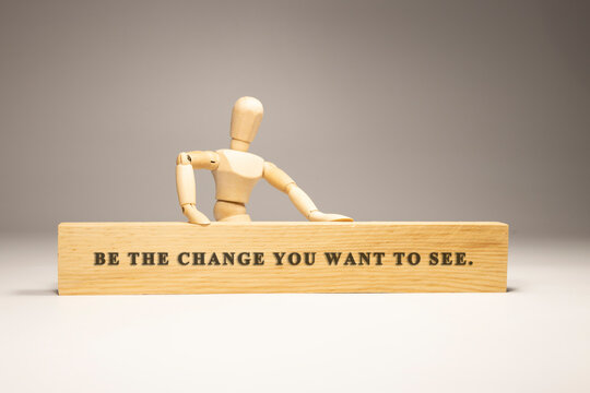 Be the change you want to see written on wooden surface. Motivation and personal development.