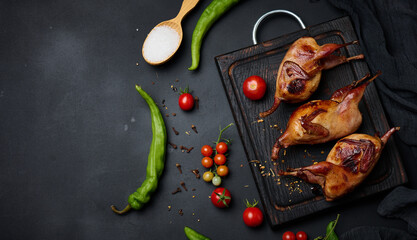 Frying carcasses of quails lie on a wooden board with vegetables