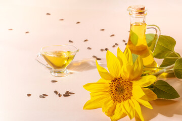 Bottle of sunflower oil and sunflower flowers on a beige background.Space for text