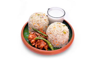 Pittu, a Sri Lankan meal with seeni sambol and coconut milk on a clay pot and a banana leaf 