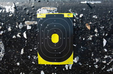 Rifle or pistol shooting target at the shooting range hanging on a backboard with staples and room...