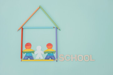 same-sex parents with their son in a school made of colored pencils