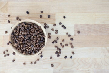 Fototapeta na wymiar Coffee beans on the wooden table in the wooden plate. Brown coffee beans 