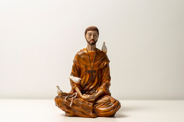 Statue of Saint Francis of Assisi. Statuette of Saint Francis of Assisi meditating. Padmasana pose. Lotus asana. Asana Padmasana