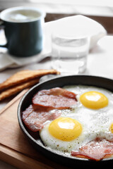 Tasty fried eggs with bacon on table, closeup. Space for text